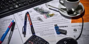 Ein Schreibtisch auf dem Kugelschreiber und Büroklammern und ein Taschenrechner liegen