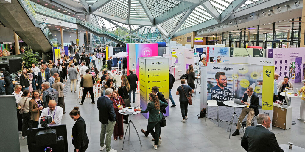 Ausstellungsbereich der B2B-Convention "ECR in Motion". Viele Menschen in einer Messehalle